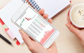 Woman holding smartphone above business desk