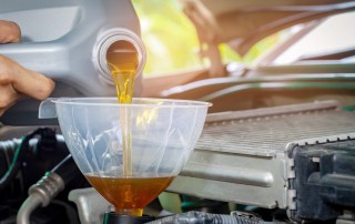 Car maintenance servicing mechanic pouring new oil lubricant into the car engine.selective focus.